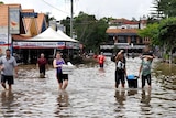 People walk through the floodwaters at Rosalie village