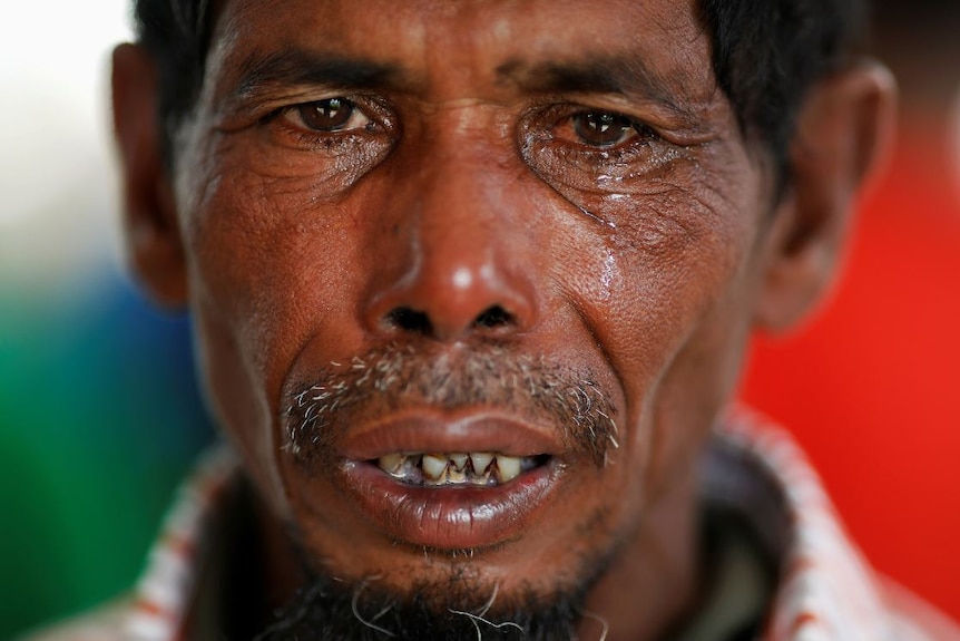 Lalu Miya cries over the bodies of his wife and children.