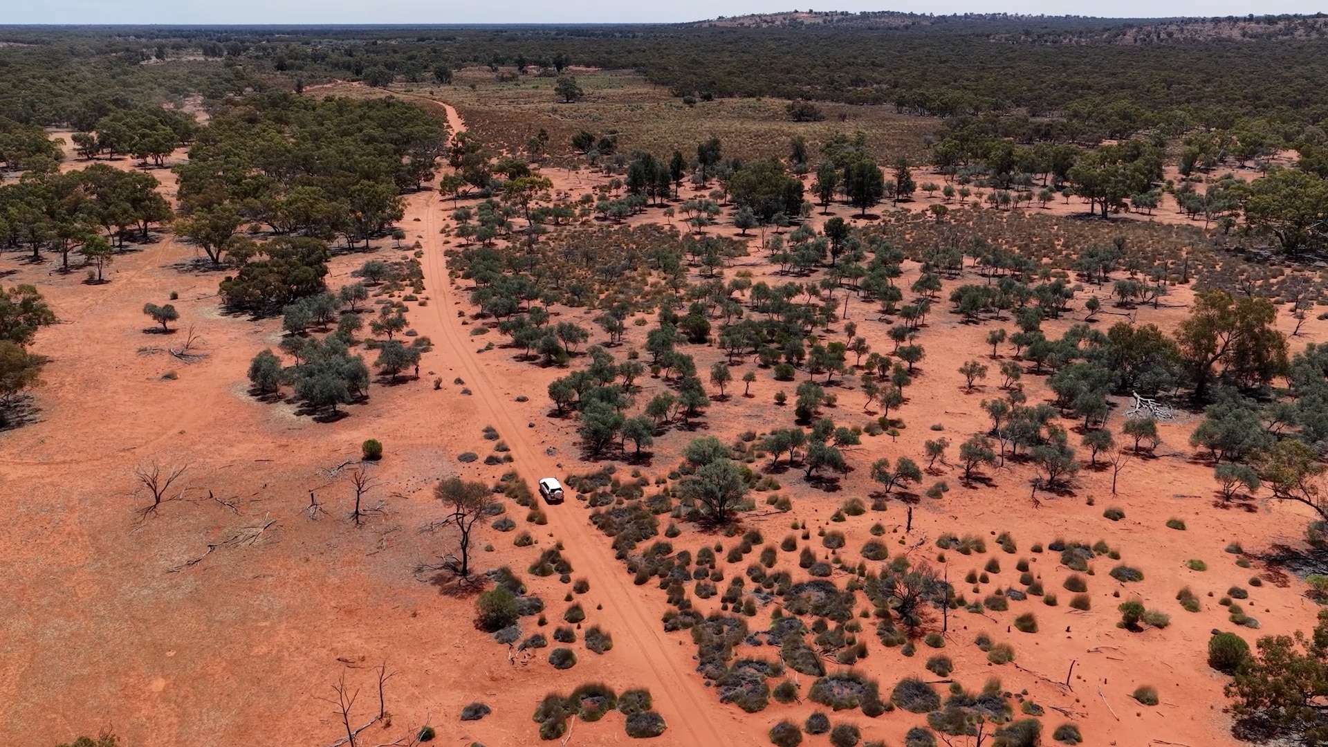 A white four wheel drive on a dirt road. 