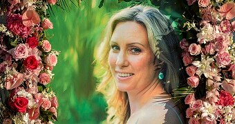 A photo of Justine Damond Ruszczyk is seen with flowers around it.