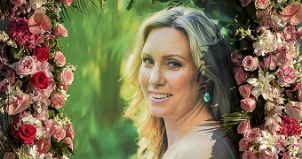 A photo of Justine Damond Ruszczyk is seen with flowers around it.