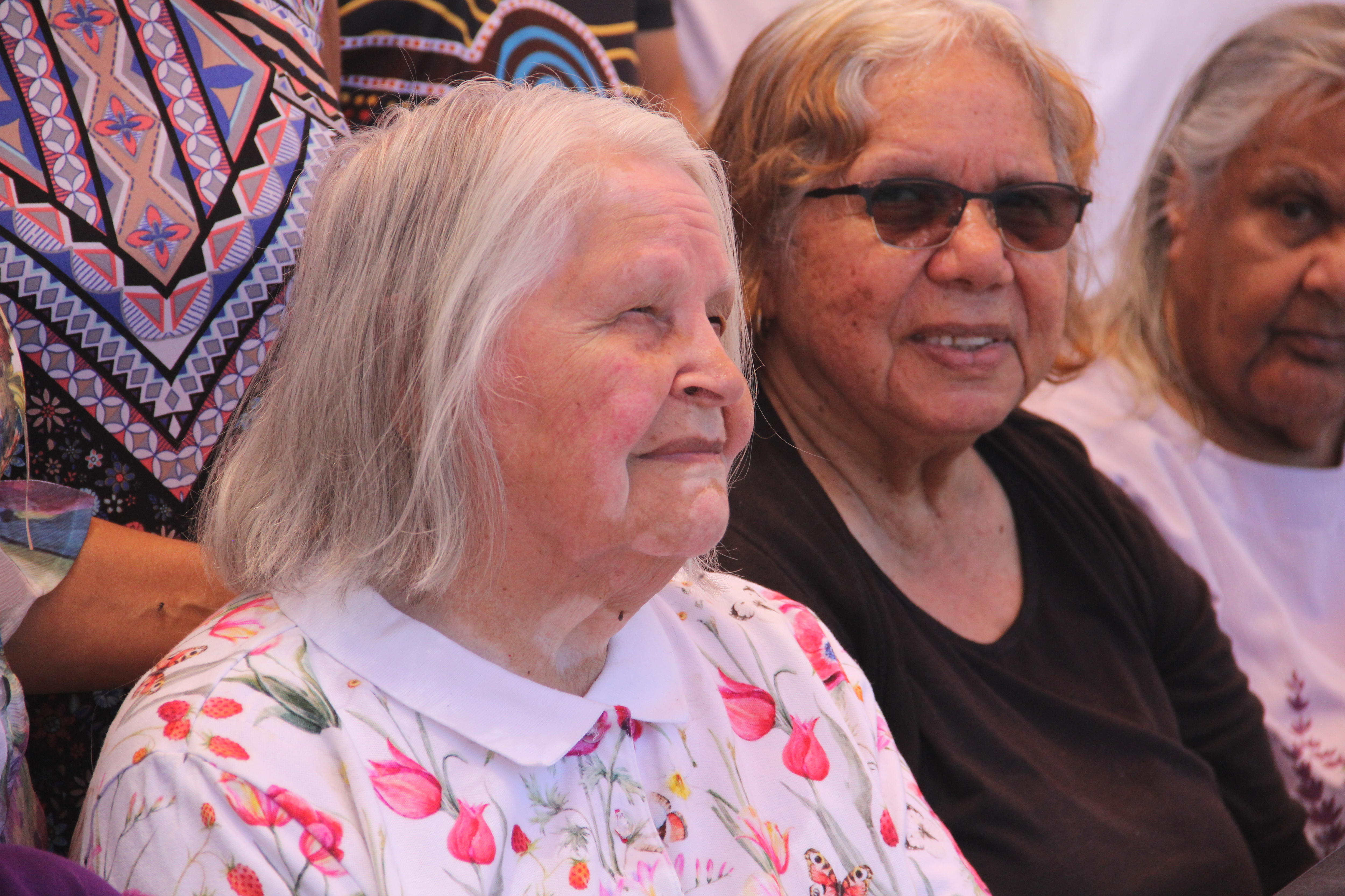 Dos mujeres de unos ochenta años con expresiones faciales neutras.