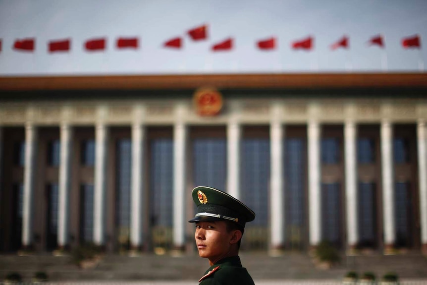 A paramilitary police officer stands in front of the Great Hall of the People in Beijing