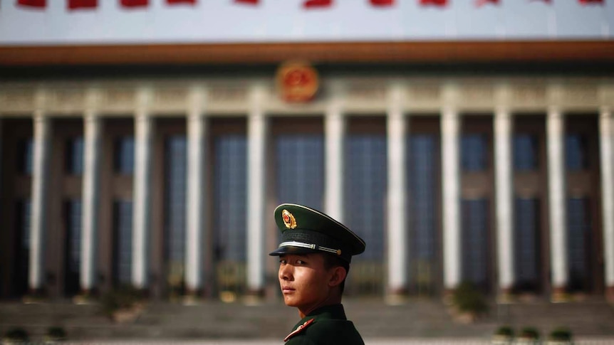 A paramilitary police officer stands in front of the Great Hall of the People in Beijing