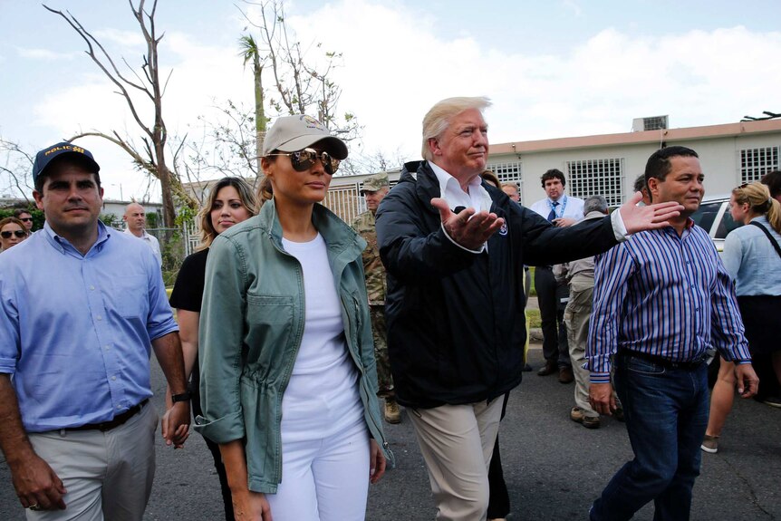 President Trump and others walk down a street in Puerto Rico.