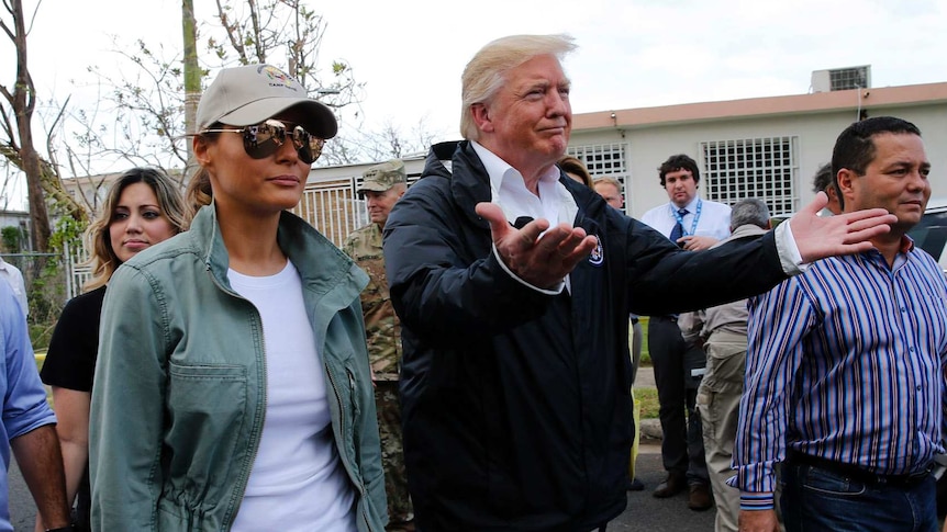 President Trump and others walk down a street in Puerto Rico.