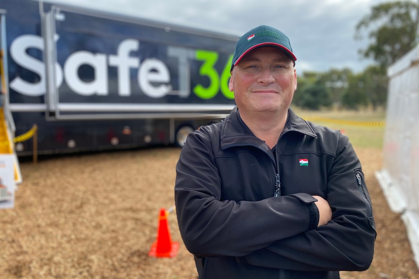 TruckSafe chair Ferdie Kroon stands with his arms crossed in front of a big 'safety' truck