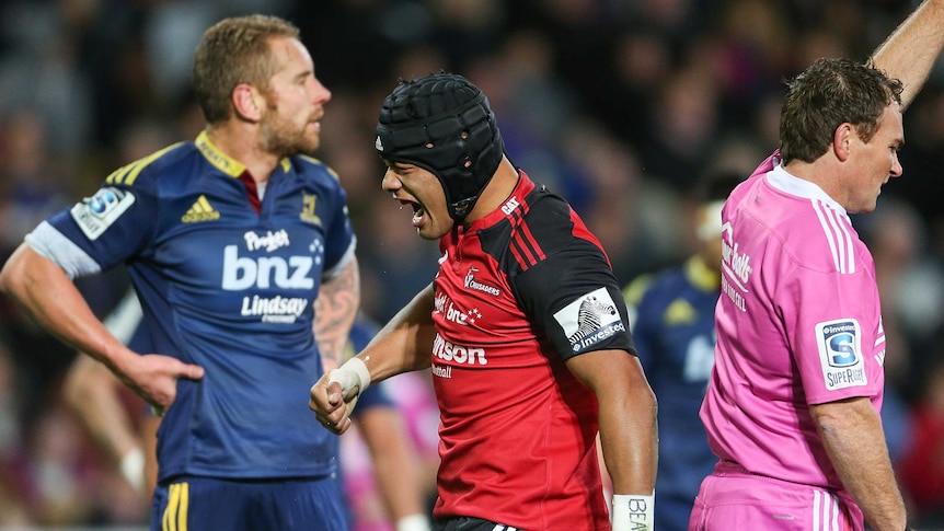 Tight contest ... Jordan Taufua (C) celebrates his try for the Crusaders