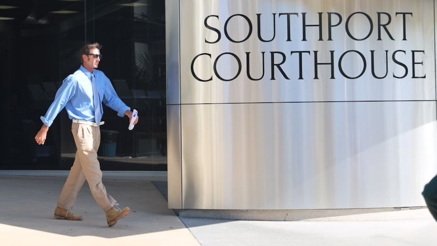 A man walking in front of a courthouse.