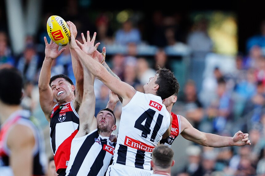 A number of St Kilda and Collingwood players collide to contest a ball in the air