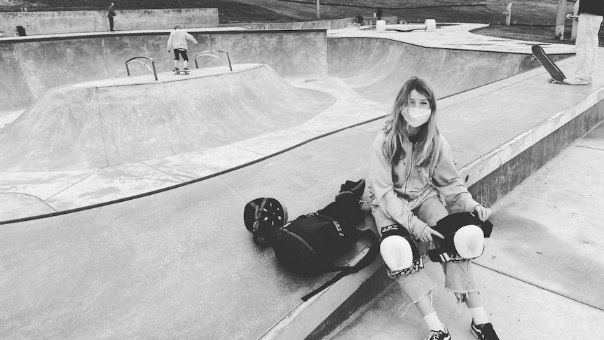 A young female skateboarder at a skate park.