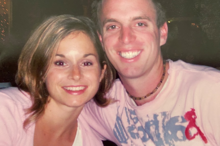 A woman with short dark blonde hair smiles next to her brother