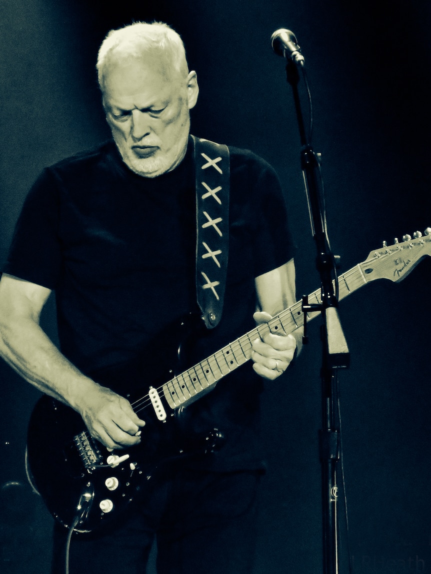 David Gilmour from Pink Floyd playing electric guitar on stage