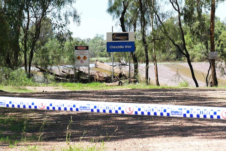 Police tape marking off a section of land near a water weir