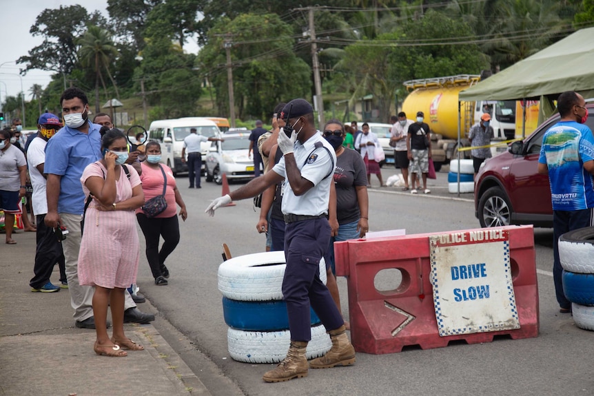 A man polices a COVID-19 containment zone checkpoint