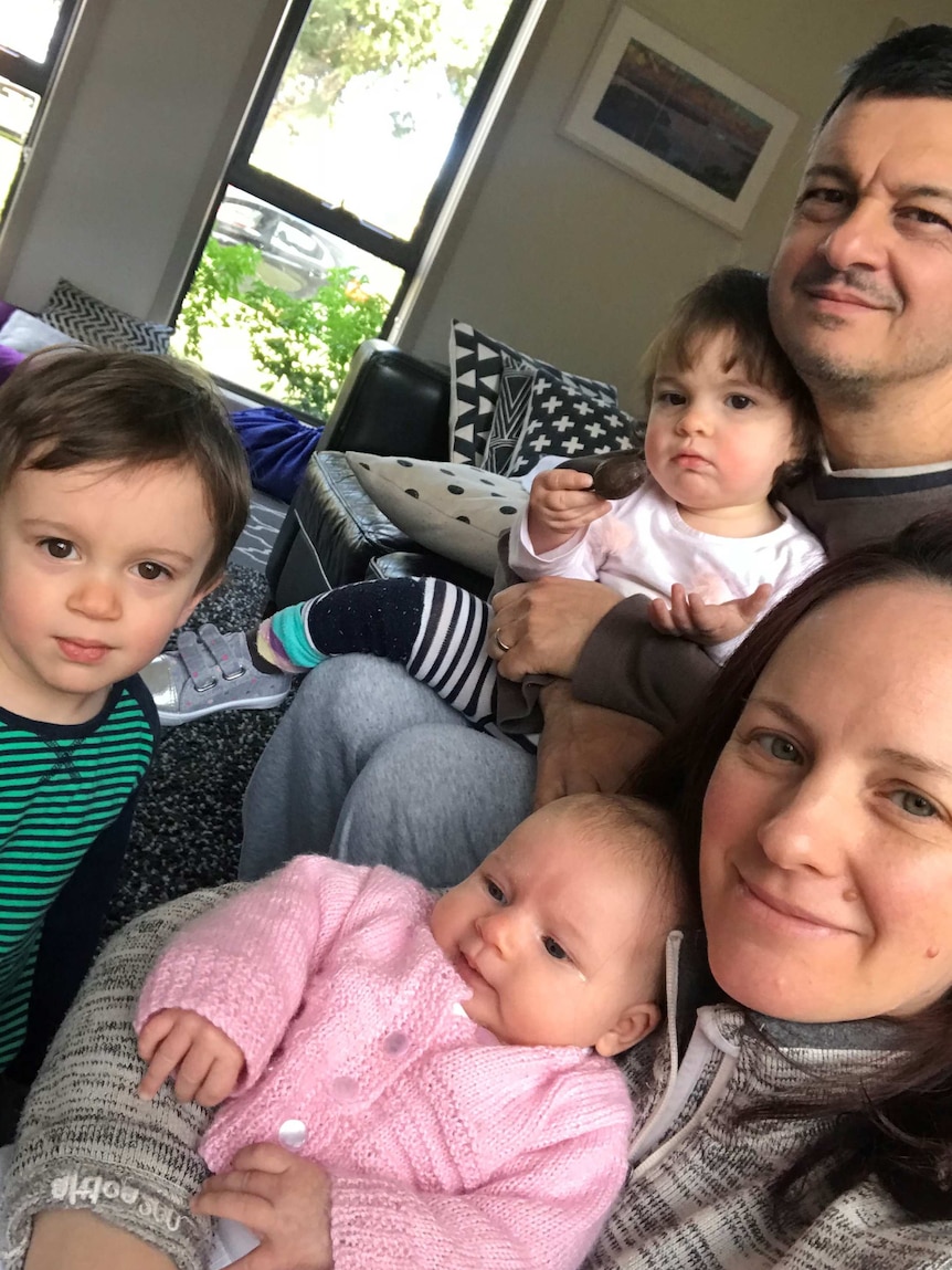 The author, his wife, and their three small children cuddling on the couch at home.