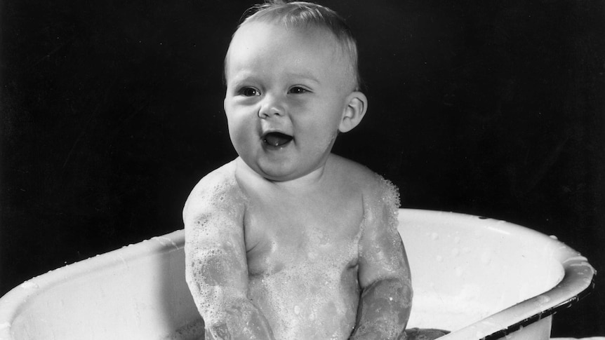 Baby in the bath with a smile and bubbles