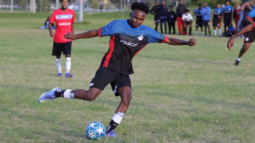 Brisbane United striker Zaki Ahmed taking a shot at goal.