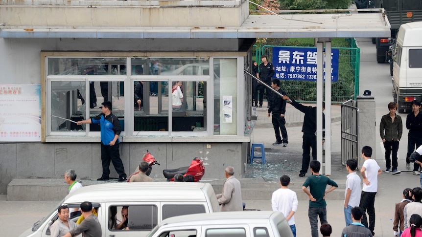 Workers clean up glass shards at Foxconn