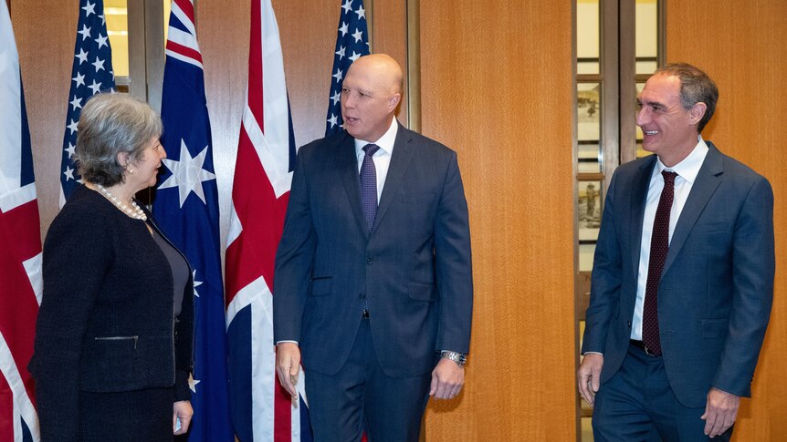Vicki Treadell on the left, Peter Dutton in the middle and Michael Goldman on the right in front of Australian, UK and US flags