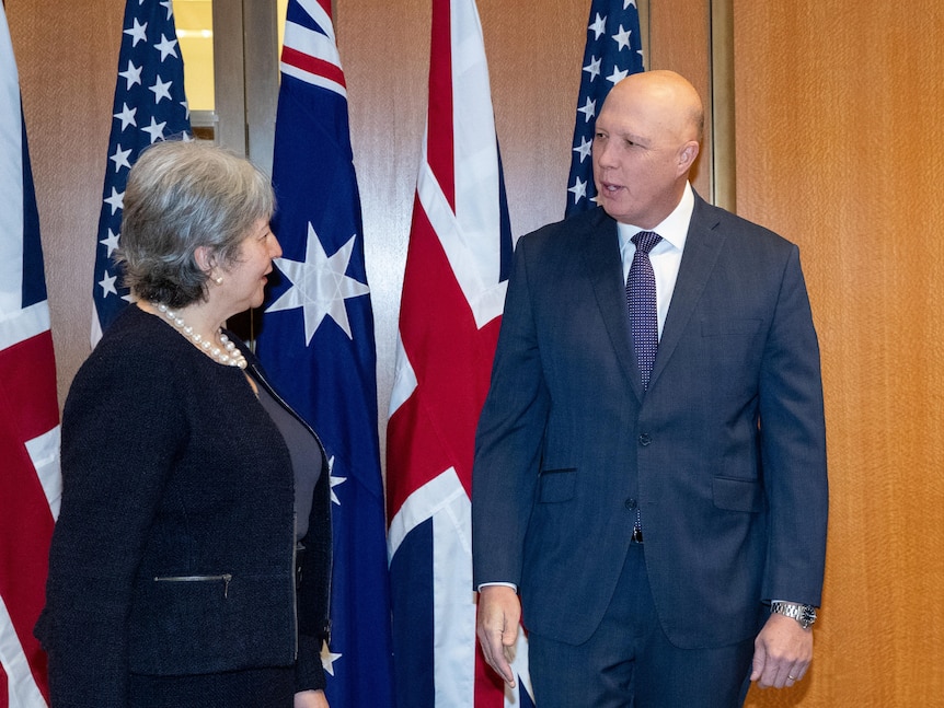 Vicki Treadell on the left, Peter Dutton in the middle and Michael Goldman on the right in front of Australian, UK and US flags