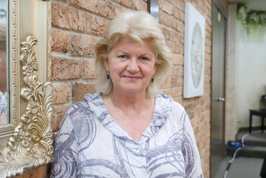 Woman standing by an exposed brick wall