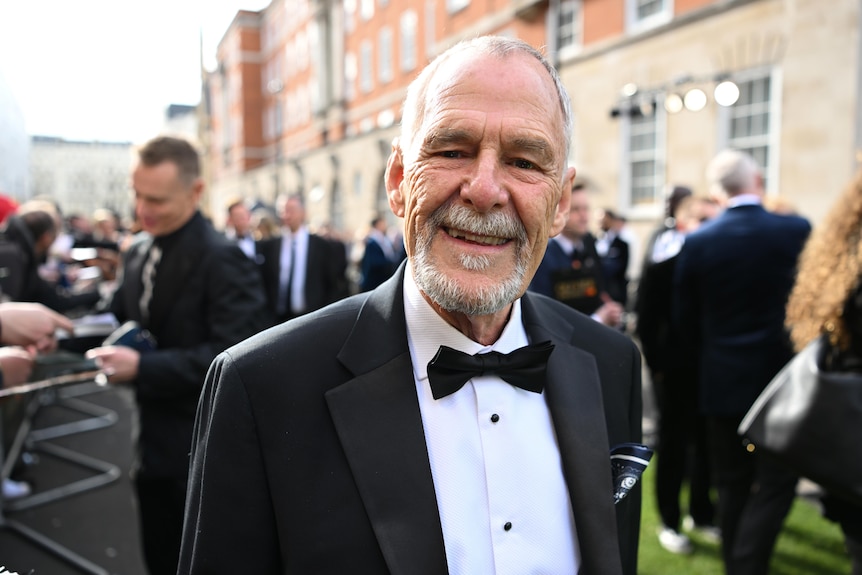 Actor Ian Gelder smiling at the camera in a black suit with a bow tie
