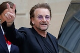 Singer Bono of U2 waves as he leaves the Elysee Palace in Paris, France.