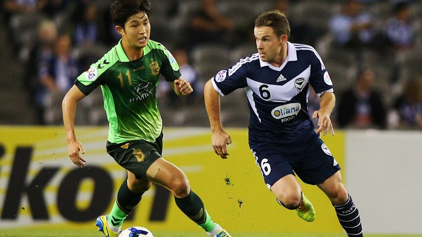 Tight challenge ... Leigh Broxham (R) of the Victory and Seunggi of Joenbuk contest for the ball