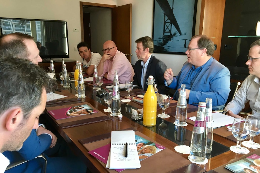 Minister Dan Tehan at a table with 10 other men