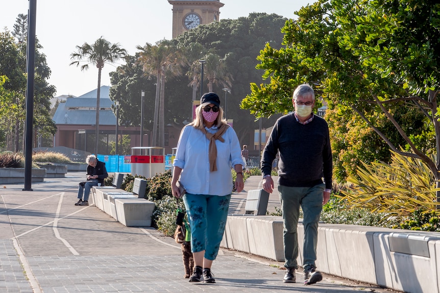 A couple with masks on walking in Newcastle