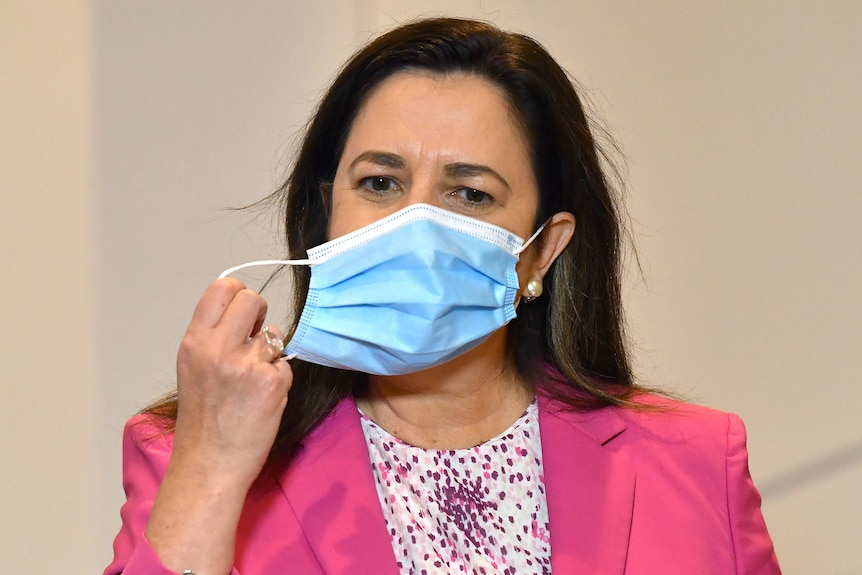 Premier Annastacia Palaszczuk removing her face mask