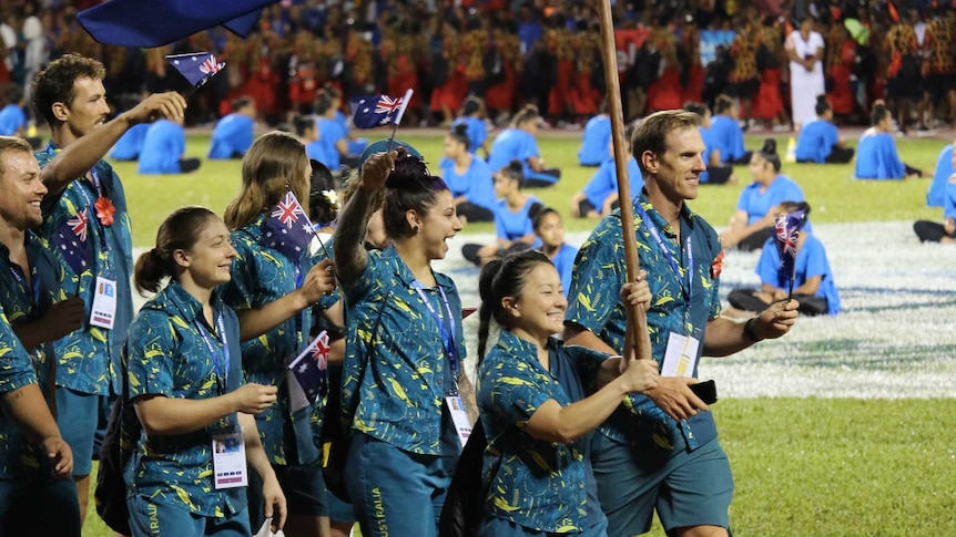 Erika Yamasaki holds the Australian flag and leads the Australian team at the opening ceremony