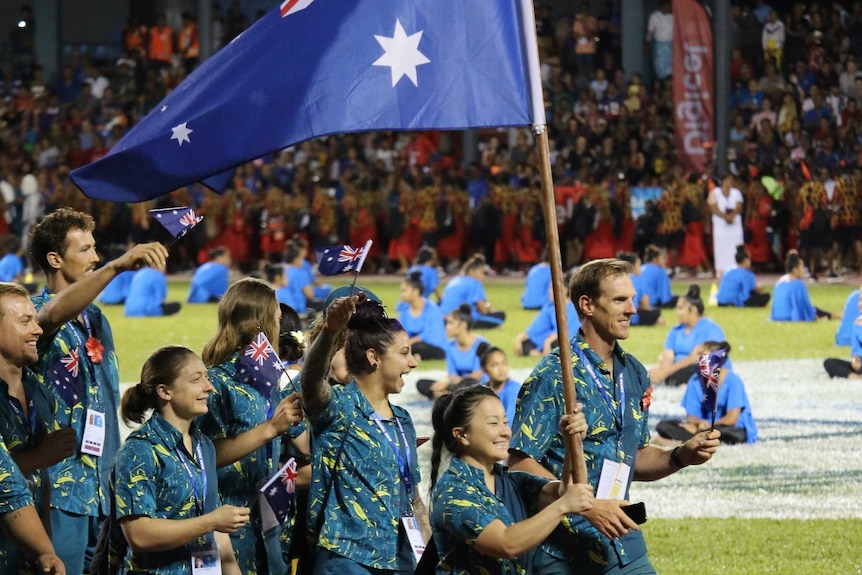 Erika Yamasaki holds the Australian flag and leads the Australian team at the opening ceremony
