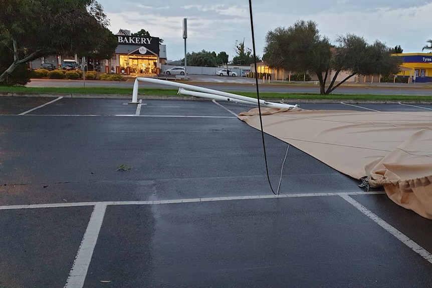A photo shows a pole meant to hold up a shade sail completely bent over due to wind.