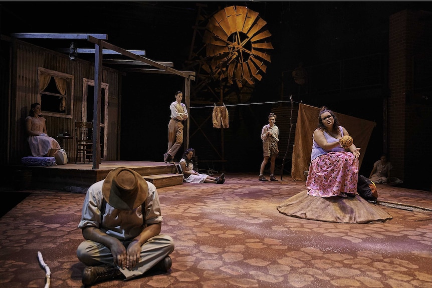 A group of Aboriginal actors on stage in a production that's set at an abandoned cattle station