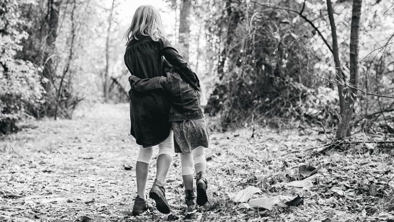 Black and white picture of two kids in a forest 