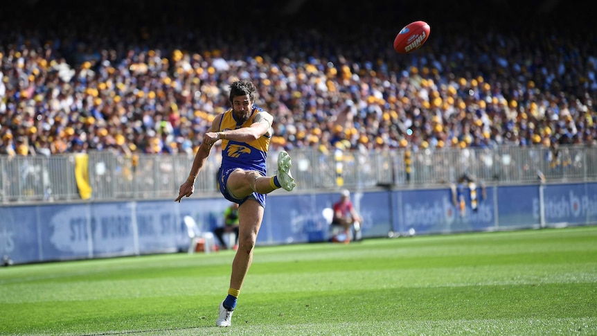 Josh Kennedy in action kicking the football for West Coast against Melbourne at Perth Stadium.