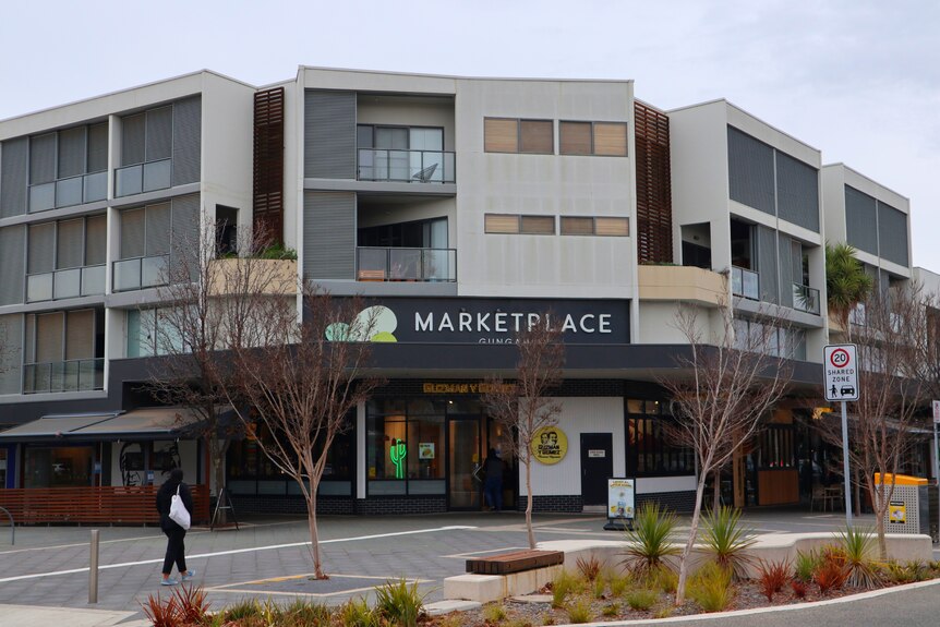 Exterior of Gungahlin Marketplace with a sign and streetscape.