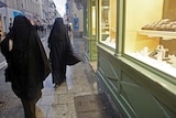 Women wearing niqabs walk past shops on the street in Marseille December 24, 2009.