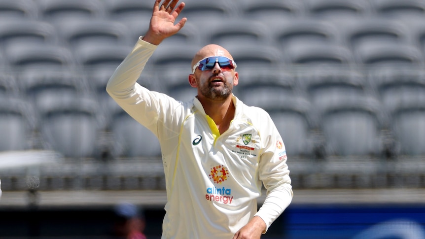 Nathan Lyon holds up his hand