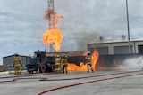 a group of CFA firefighters put out a fire in a tanker truck during a simulation. 