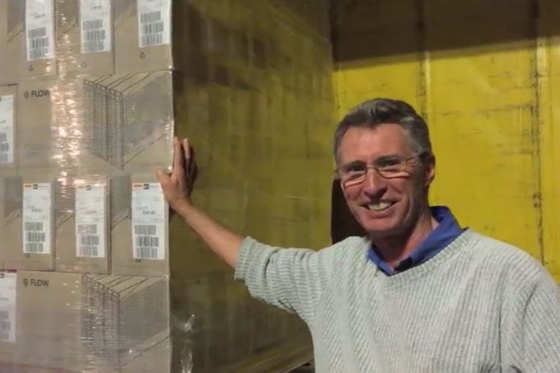 Flow Hive inventor Stuart Anderson standing with a pallet load of orders.