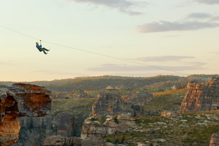 An artist's impression of a man on a zipwire crossing a canyon.