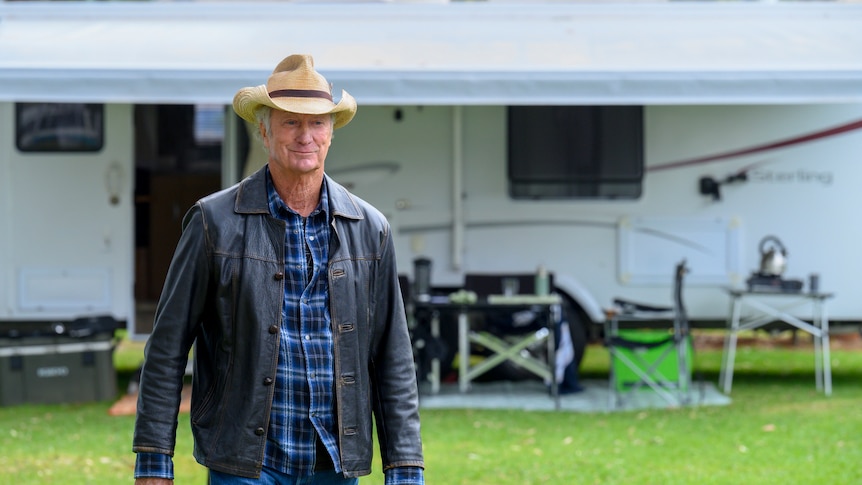 Bryan Brown walking outdoors at a caravan park in a scene from Darby and Jones.