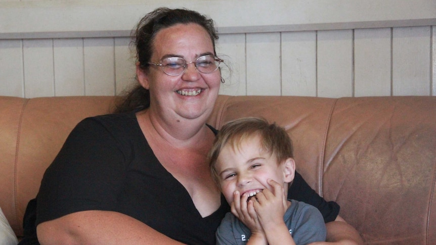 A woman and a young boy sit on a couch