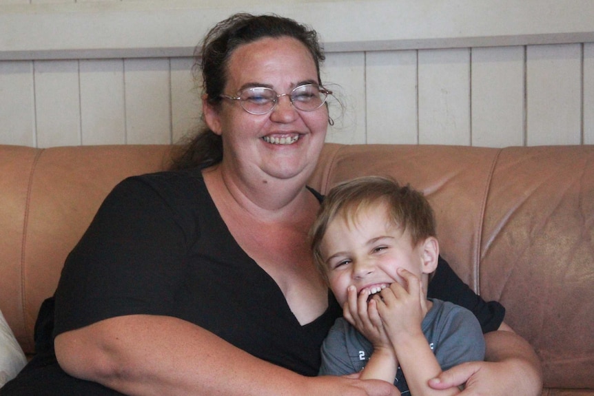 A woman and a young boy sit on a couch