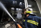 Fireman sprays water on damaged Athens building