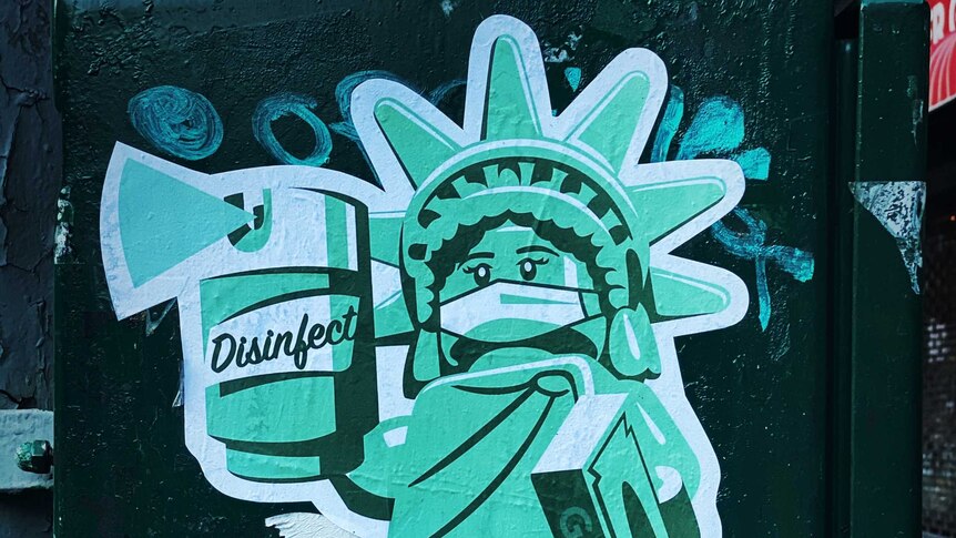 Graffiti showing the Statue of Liberty wearing a mask and using sanitiser