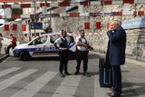 French police officers stand beside their car which is blocking a drive way outside the Marseille's St Charles train station